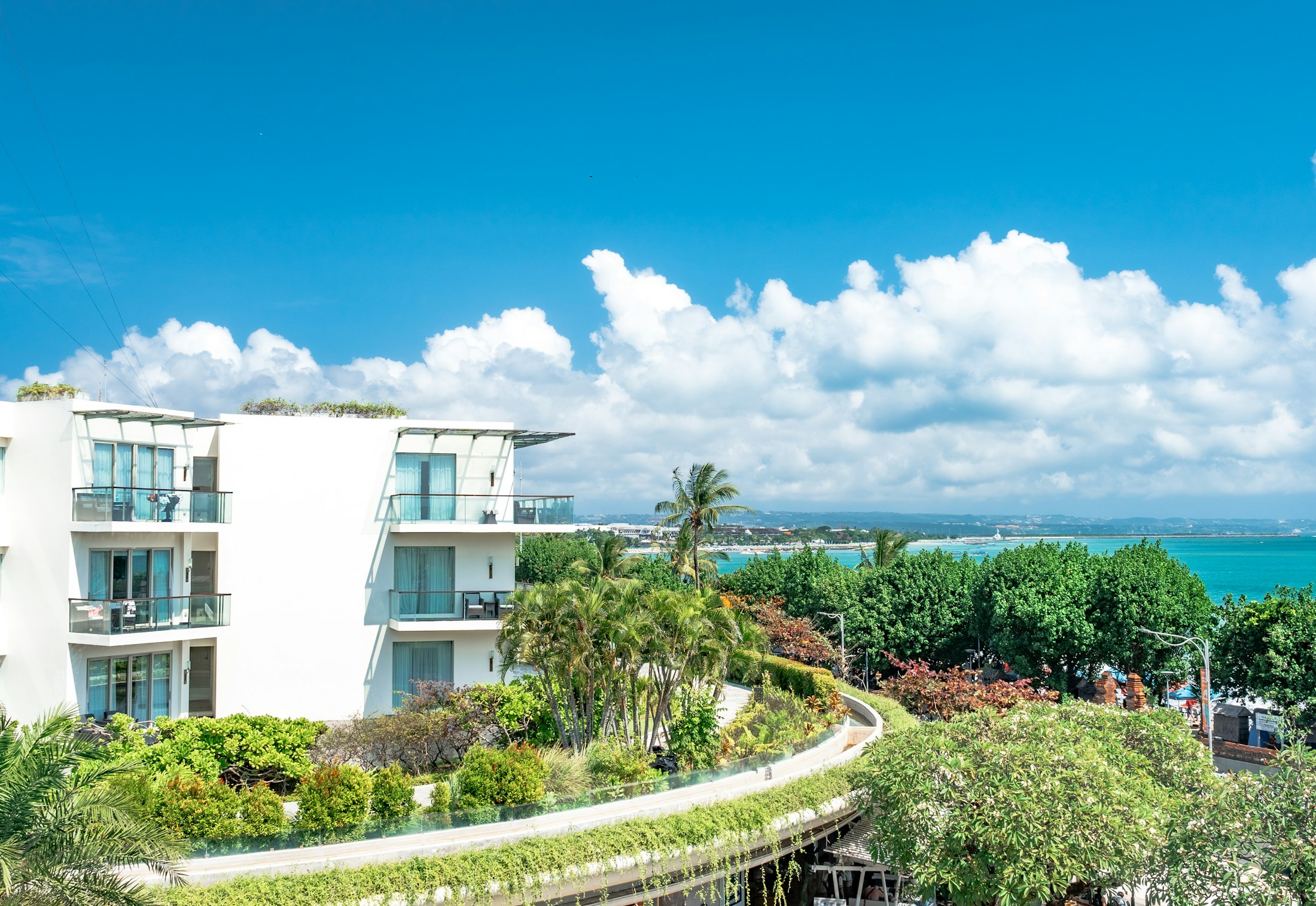 Modern white architecture overlooking greenery and the ocean